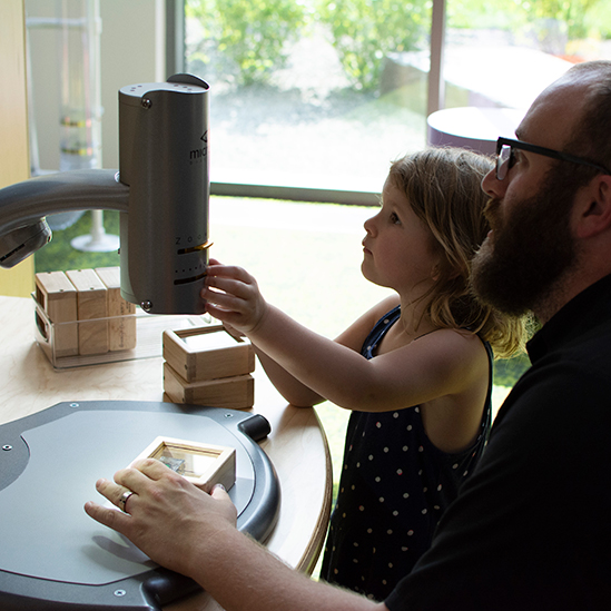 girl and father at a video microscope station